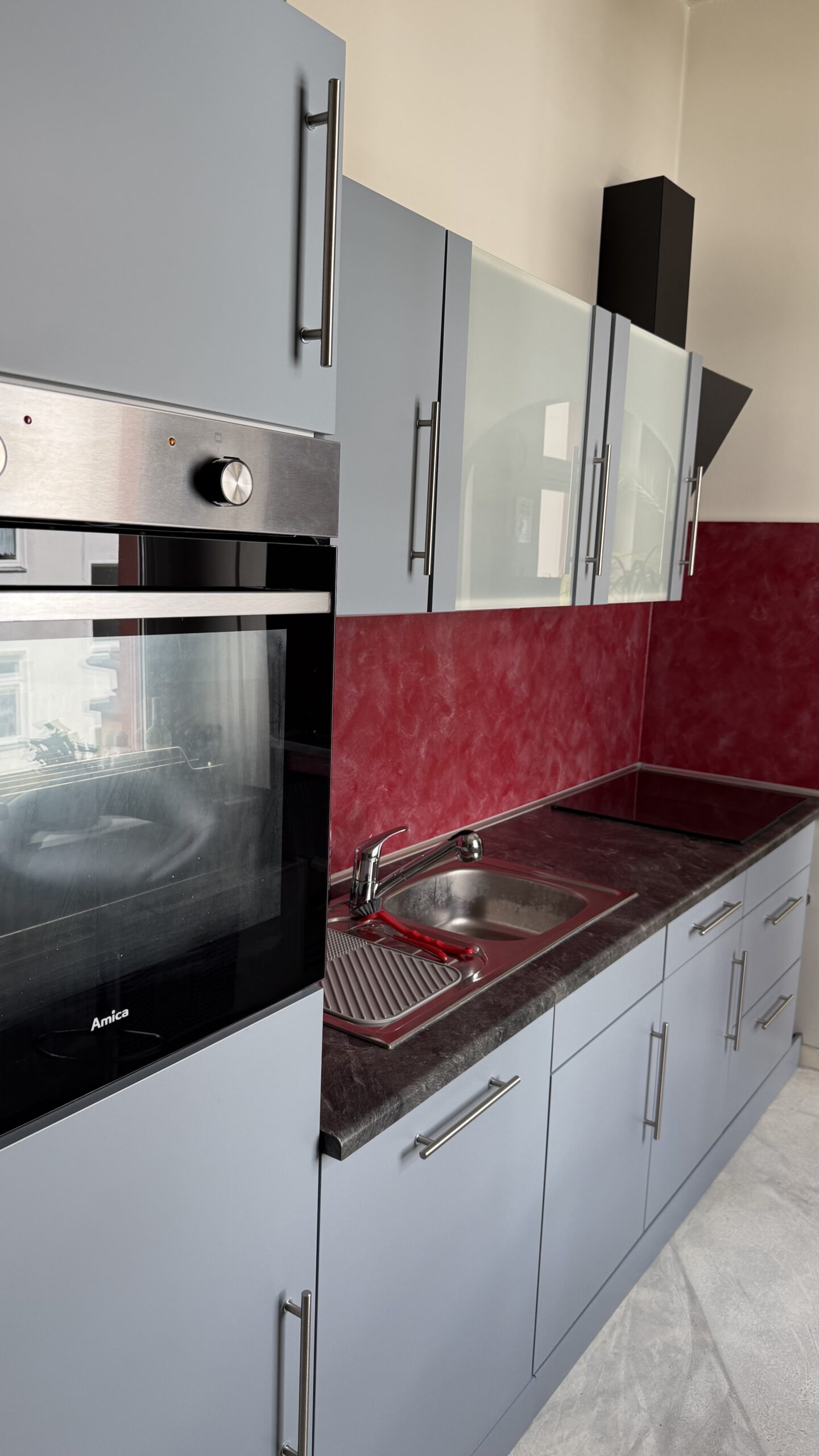 Möbellackierungen in Berlin – hochwertige Küche nach der Möbellackierung mit modern lackierten Küchenfronten in Hellgrau und stilvoller Oberflächenveredelung.