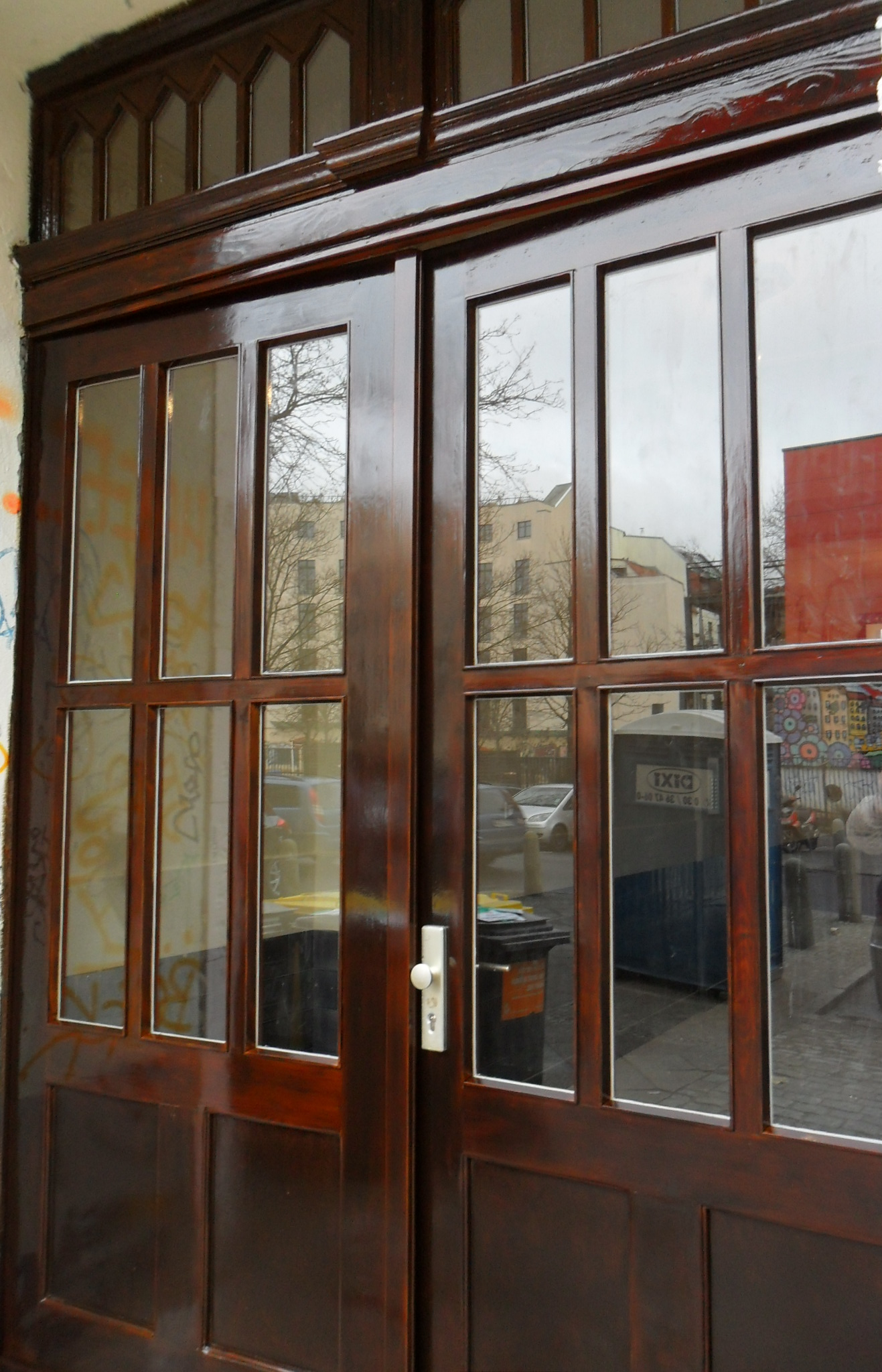 Aufbereitete Holz-Eingangstür mit glänzender Schutzlasur nach fachgerechten Holzschutzarbeiten in Berlin